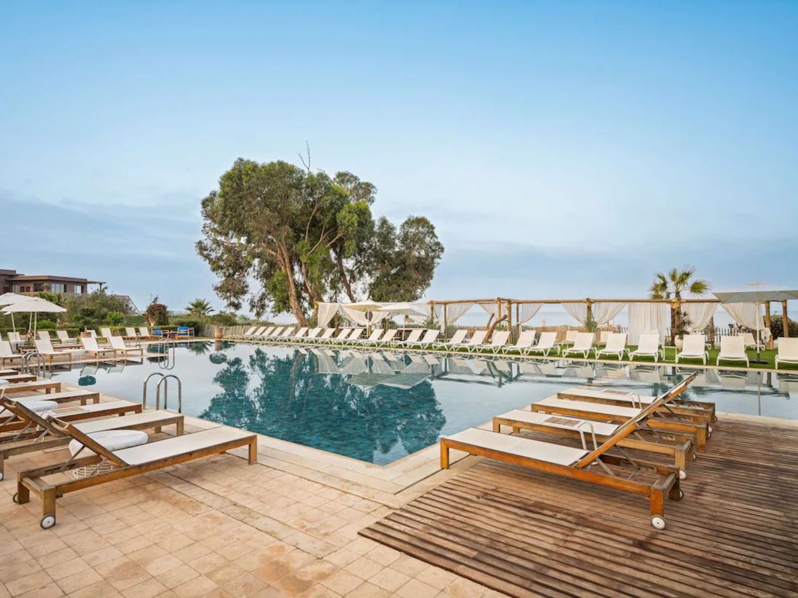 Rondreis Marokko, Taghazout, Radisson Blu Resort Taghazout Bay Surf, zwembad met liggenstoelen